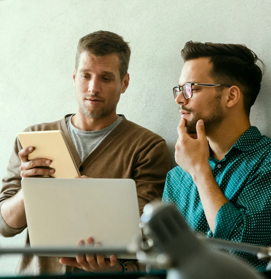 Two man talking about something on front of laptop