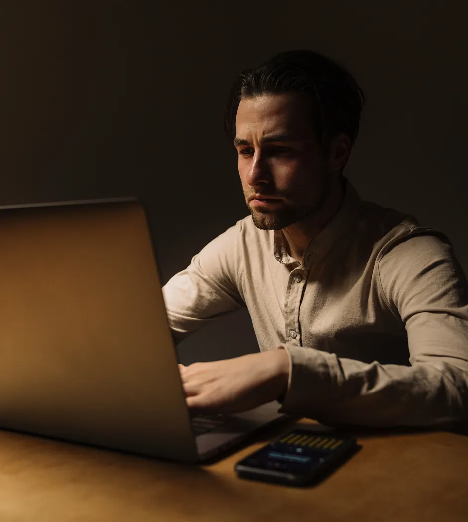 A man standing in front of laptop, working on it