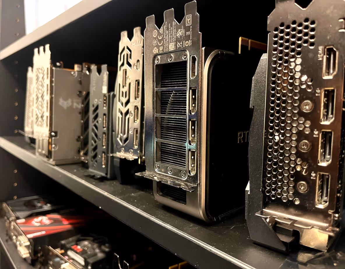 A shelf with various graphics cards next to each other with the display ports facing the camera.