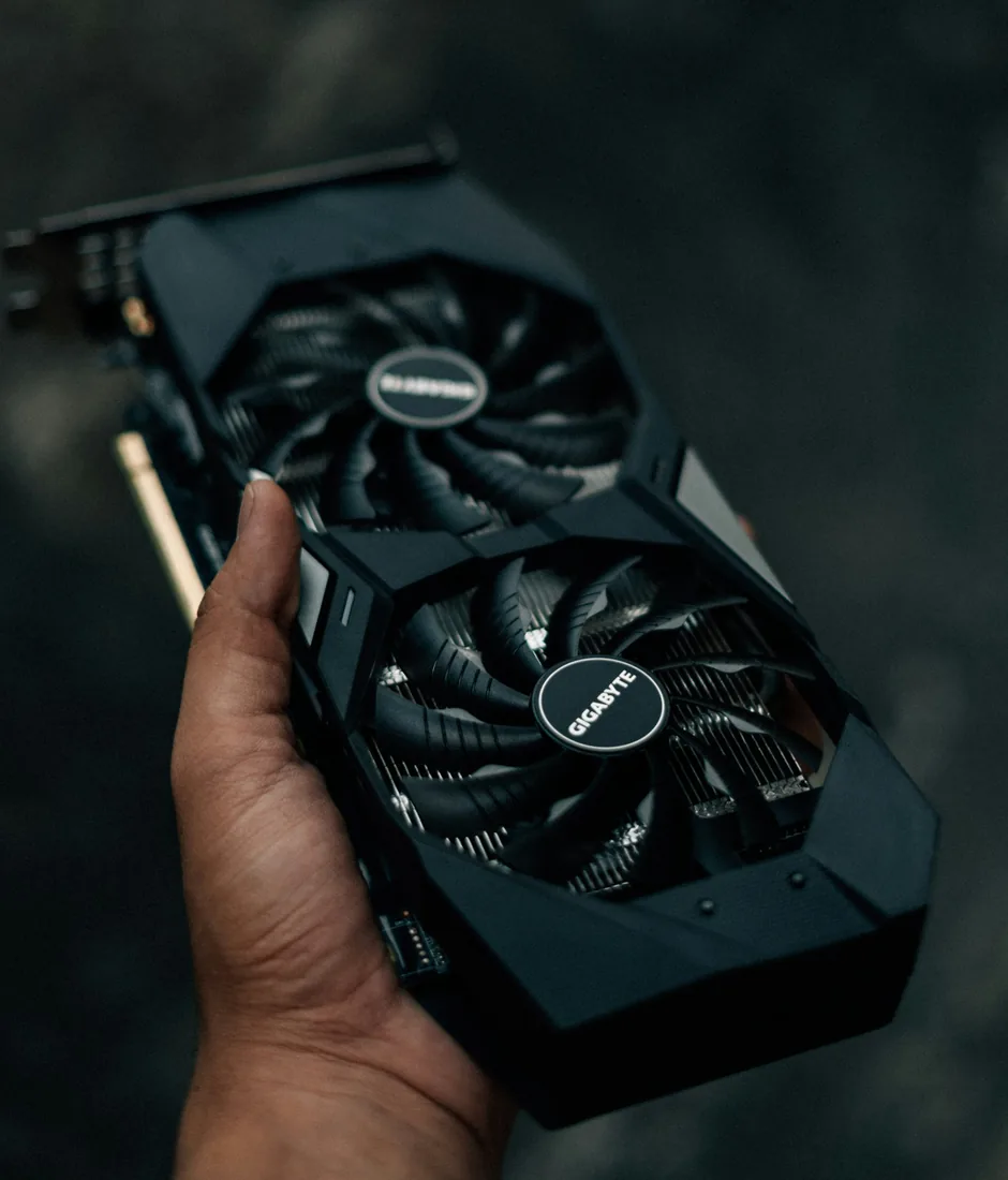 A hand holding a dual-fan graphics card