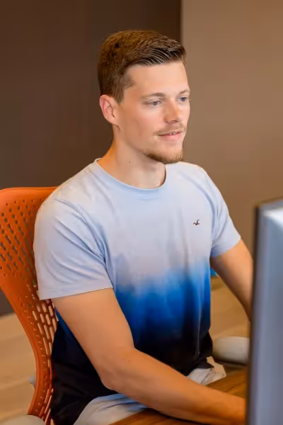 Marijn Suijten sitting in front of computer screens, working